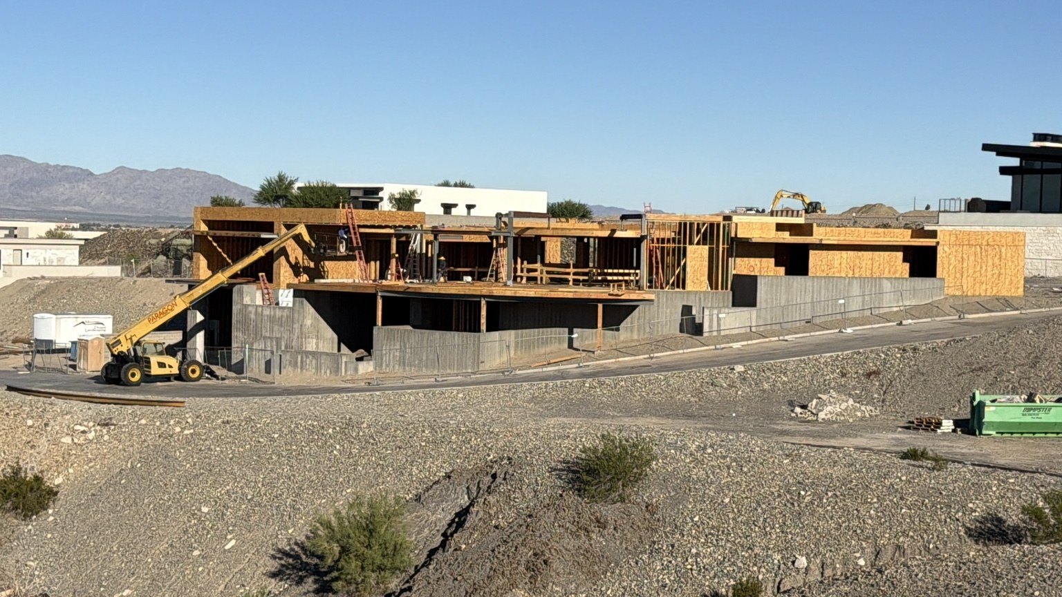 Wide view of two-story custom home framing with wood and steel